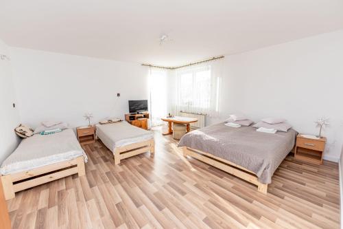 Habitación blanca con 2 camas y mesa en Resia, en Krynica-Wieś