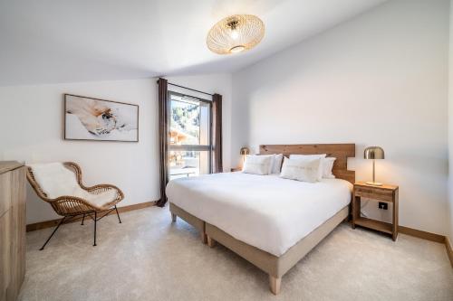 a bedroom with a bed and a chair and a window at Apartment Clematis Les Gets- BY EMERALD STAY in Les Gets