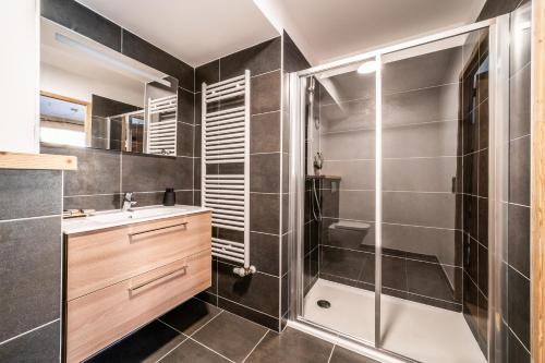 y baño con ducha y lavamanos. en Apartment Clematis Les Gets- BY EMERALD STAY en Les Gets