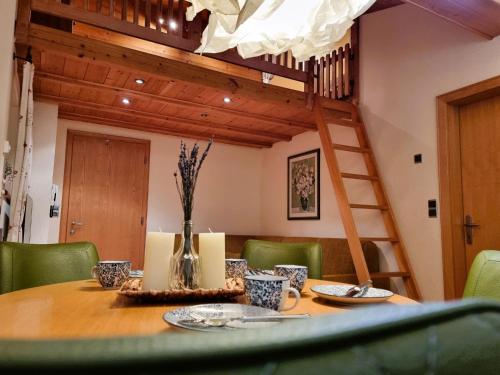 une table à manger avec des chaises vertes et une échelle dans l'établissement Apartment Rätia II by Interhome, à Pfunds