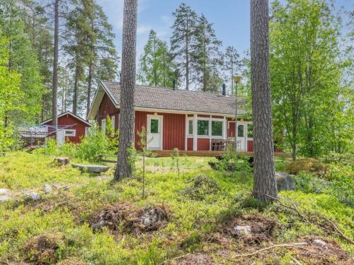 ein rotes Haus im Wald mit Bäumen in der Unterkunft Holiday Home Malmi by Interhome in Jyrkkä