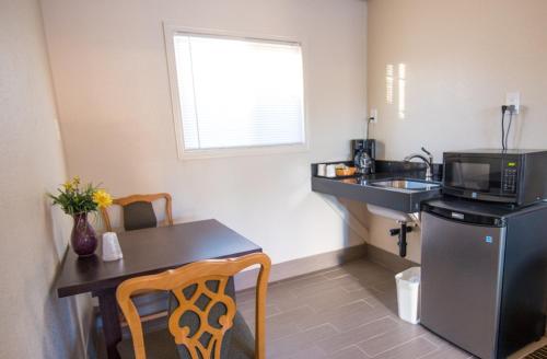 a small kitchen with a table and a microwave at Budget Lodge Eugene - Airport in Eugene