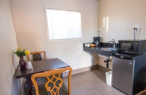 a small kitchen with a table and a microwave at Budget Lodge Eugene - Airport in Eugene