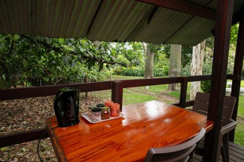 a wooden table with a coffee maker on a porch at Crocodile Nest B&B in Nelspruit