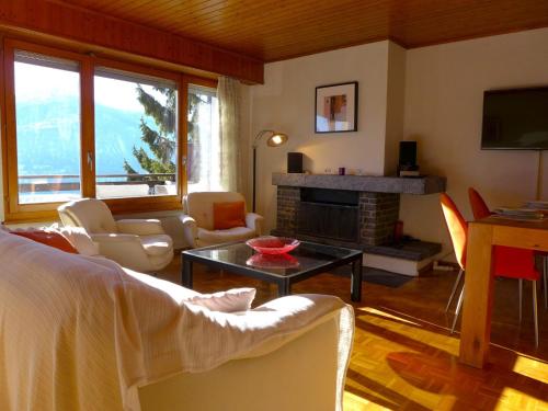 a living room with a couch and a fireplace at Apartment Résidence Maze B 10 by Interhome in Chermignon-dʼen Haut