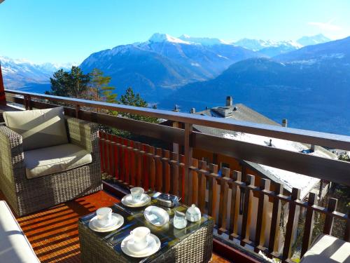een balkon met een tafel en stoelen en bergen bij Apartment Maze B by Interhome in Chermignon-dʼen Haut