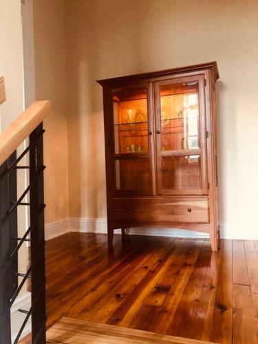 a wooden cabinet with glass doors in a room at Triple Brick on Main in Wyalusing