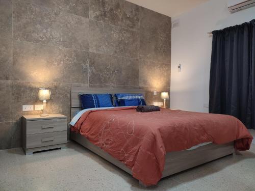 um quarto com uma grande cama vermelha com almofadas azuis em Dolphin Court 3-Bedroom Sea View Apartment in Marsaskala, Malta em Marsaskala