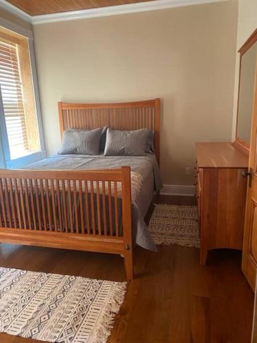 a bedroom with a wooden bed and a wooden dresser at Triple Brick on Main in Wyalusing