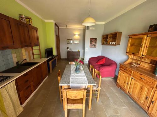 a kitchen with a table and a red couch at Violet Home Irpinia in Montemarano