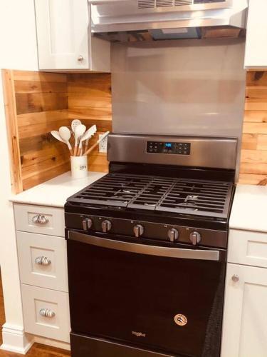 a black stove in a kitchen with white cabinets at Triple Brick on Main in Wyalusing
