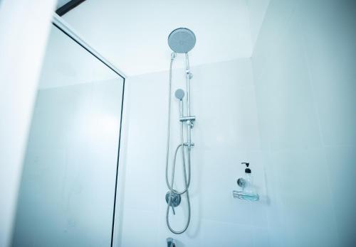 een douche met een douchekop in een badkamer bij Teya Beach Hotel in Ahangama