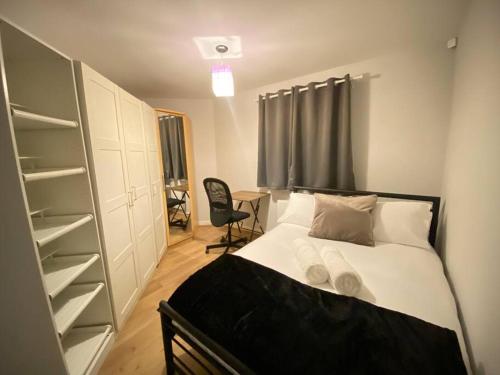 Dormitorio pequeño con cama y armario en Spacious 2 bed flat ideal for long stays, en Purfleet