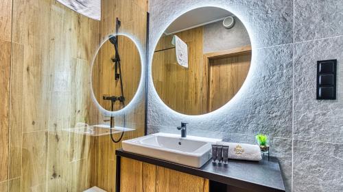 a bathroom with a sink and two mirrors at Apartamenty z basenem ROYAL APARTS Złoty Horyzont VIP, SPA i restauracja in Szklarska Poręba