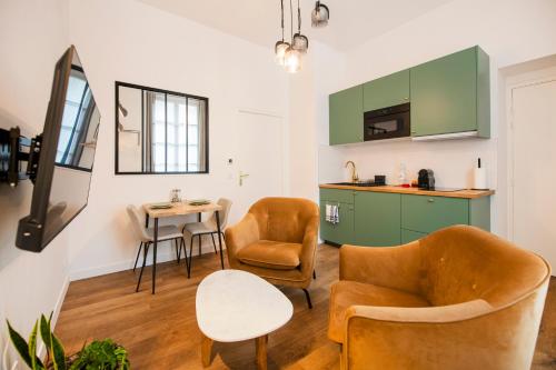 een woonkamer met 2 stoelen en een tafel bij Le Laurencin Sens - Le Keys in Sens