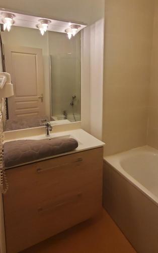 une salle de bain avec un lavabo, une baignoire et un miroir dans l'établissement Le Canal superbe maison Climatisation Wi-Fi Parking Jardin Piscine 15 mn de Béziers, à Colombiers