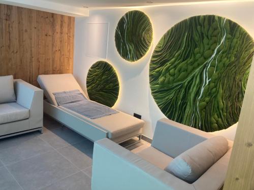 a hospital room with two beds and a painting of green leaves at Genuss-Pension Herti in Übelbach