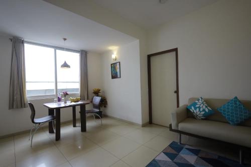 a living room with a table and a couch at Ixora Suites in Bengaluru