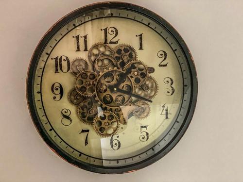 a clock with gears and numbers on a wall at Hostal Ca'n Pep in Sa Ràpita