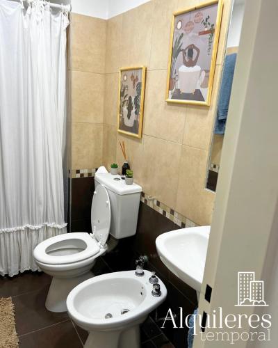 a bathroom with a white toilet and a sink at suipacha 437 in Rosario