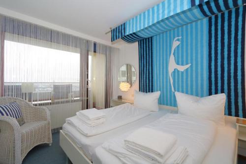 a bedroom with a bed and a chair and a window at Haus Metropol 175 OB in Westerland (Sylt)