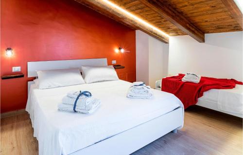 um quarto com 2 camas e uma parede vermelha em Lovely Home In San Marco Castellabate With Jacuzzi em San Marco di Castellabate