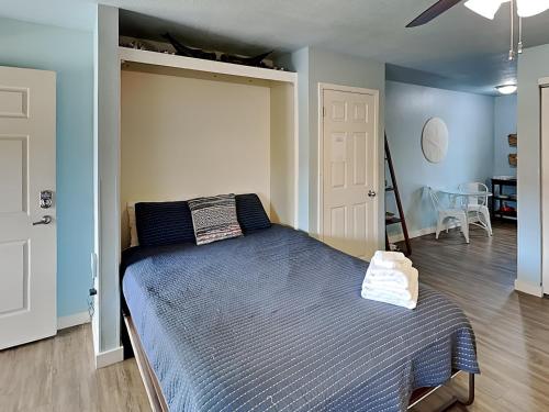 - une chambre avec un lit et une couette bleue dans l'établissement Cozy Coconut, à Port Aransas