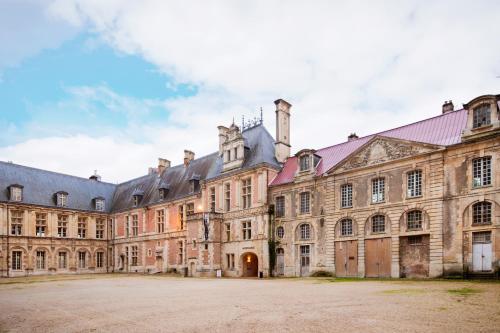 a large building with a courtyard in front of it at Le Laurencin Sens - Le Keys - Cœur de ville in Sens