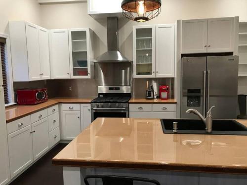 a kitchen with white cabinets and a stainless steel refrigerator at The Cast Iron Lady in Wyalusing