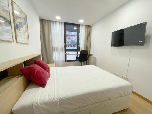1 dormitorio con cama blanca y almohada roja en MarBarcelona Suites Berlin, en Barcelona