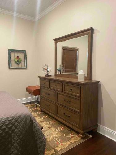 a bedroom with a dresser with a mirror on it at The Cast Iron Lady in Wyalusing
