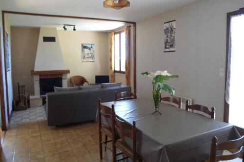 a living room with a table and a couch at En Périgord Noir paulin maison au calme proche in Paulin