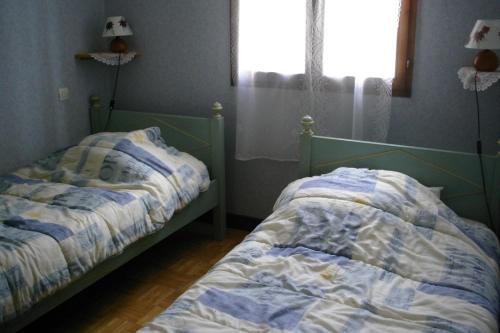 a bedroom with two beds and a window at En Périgord Noir paulin maison au calme proche in Paulin