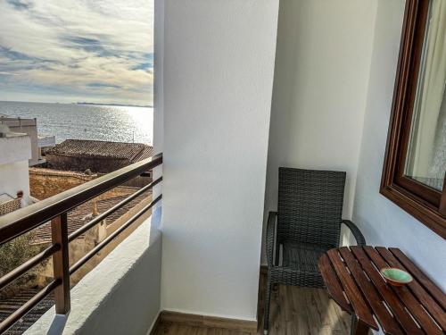 a balcony with a chair and a table and the ocean at Hostal Ca'n Pep in Sa Ràpita