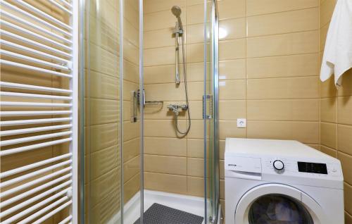 a bathroom with a washing machine and a shower at Stunning Home In Ivanska With Outdoor Swimming Pool in Ivanska