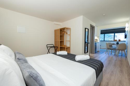 a bedroom with a large white bed and a table at Athens Airport Living spaces in Spáta