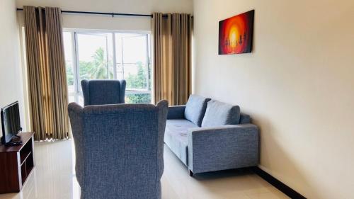 uma sala de estar com duas cadeiras e um sofá em Bluewind Luxury Apartment - 2rooms - Wattala-Hemas Hospital em Wattala