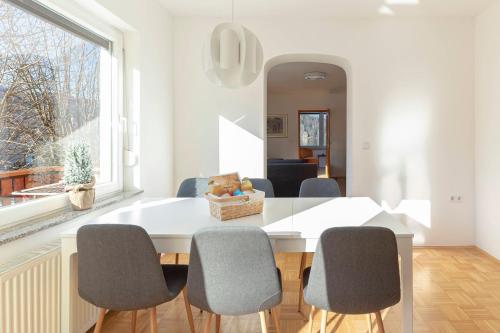 un comedor blanco con mesa y sillas en Lakeview Bled Heaven Apartments, en Bled