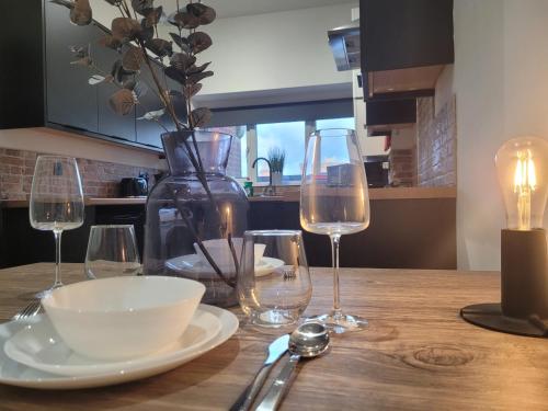 a table with wine glasses and a bowl and a vase at Stay @ The Old Bank, Burton on Trent in Burton upon Trent