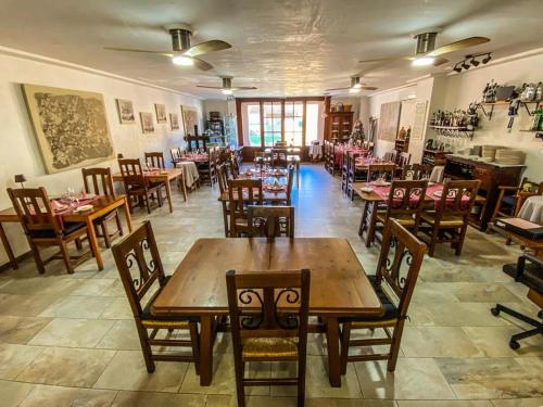 un restaurante con mesas de madera y sillas en una habitación en Hostal Ca'n Pep en Sa Ràpita