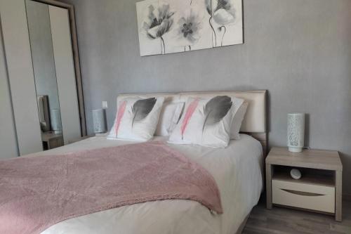 Schlafzimmer mit einem Bett mit weißer Bettwäsche und Kissen in der Unterkunft L'Ozen in Fréland