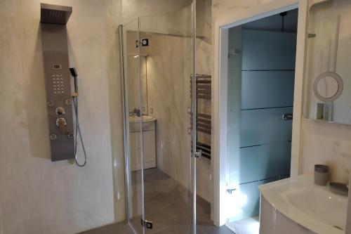 ein Bad mit einer Glasdusche und einem Waschbecken in der Unterkunft L'Ozen in Fréland