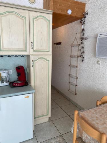 Appartement au pied des pistes- Piau Engaly في أراغنويت: مطبخ بدولاب بيضاء وقمة كونتر