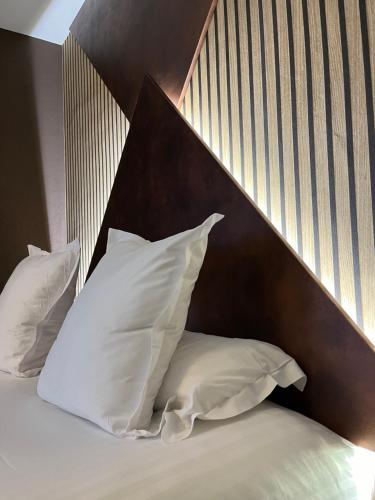 Una cama o camas en una habitación de LOGIS Hôtel Borel