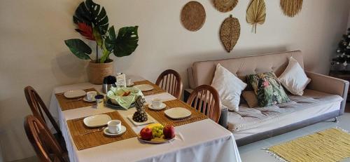een tafel met een bank in de woonkamer bij Casa noites tropicais in Imbassai