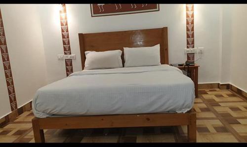 a bedroom with a large bed with a wooden headboard at FabHotel Rudraksh Resort in Mussoorie