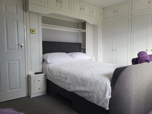 una camera da letto con un grande letto con lenzuola bianche di Almost Heaven a Acton Trussell
