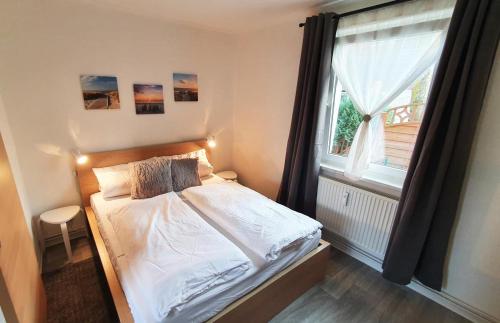 een kleine slaapkamer met een bed en een raam bij Hanni, wenige Minuten zum Strand in Warnemünde