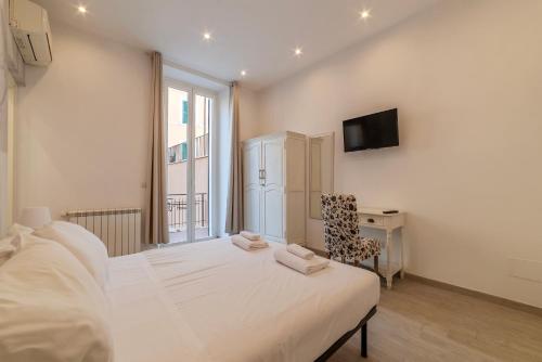 a bedroom with a white bed and a tv on the wall at Major 93 Guesthouse in Rome