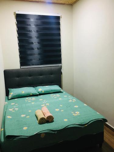 een slaapkamer met een bed met twee handdoeken erop bij The Pines House @ PCB (home stay) in Kota Bharu